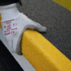 Close up of a gloved hand installing stair treads on the end of a step