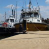 Beige mini mesh used as a pontoon with boats at the end and water to the left of it