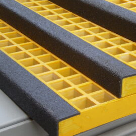 Close up of yellow stair treads with three black nosings