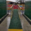 Green access ramp with yellow mesh edging in wet conditions