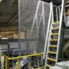 Screen Guard Mesh next to a Ships Ladder in a factory
